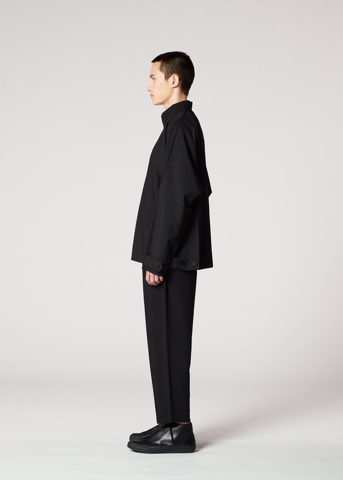 A model wears the IM MEN FLAT BLACK trousers.
