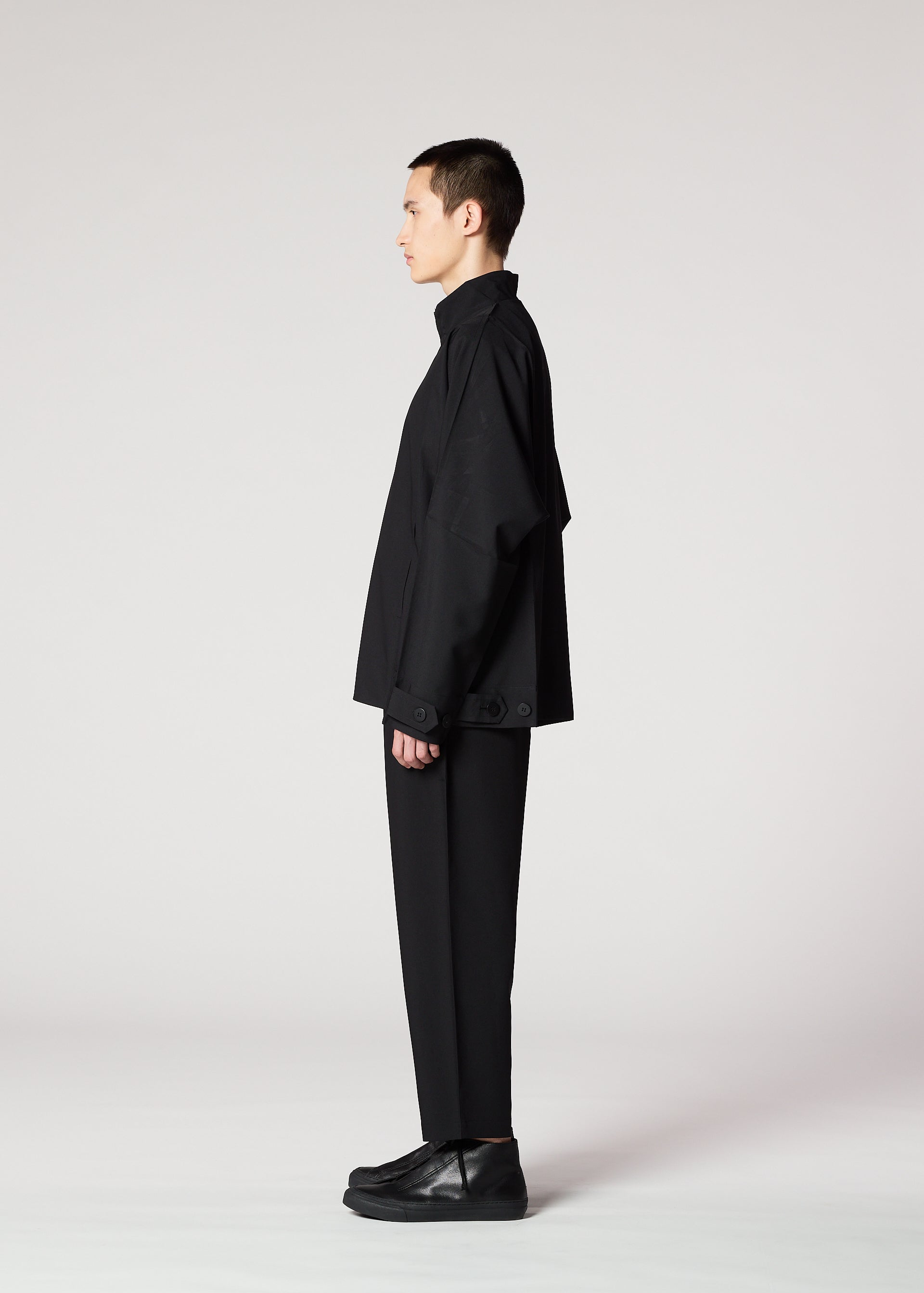 A model wears the IM MEN FLAT BLACK trousers.