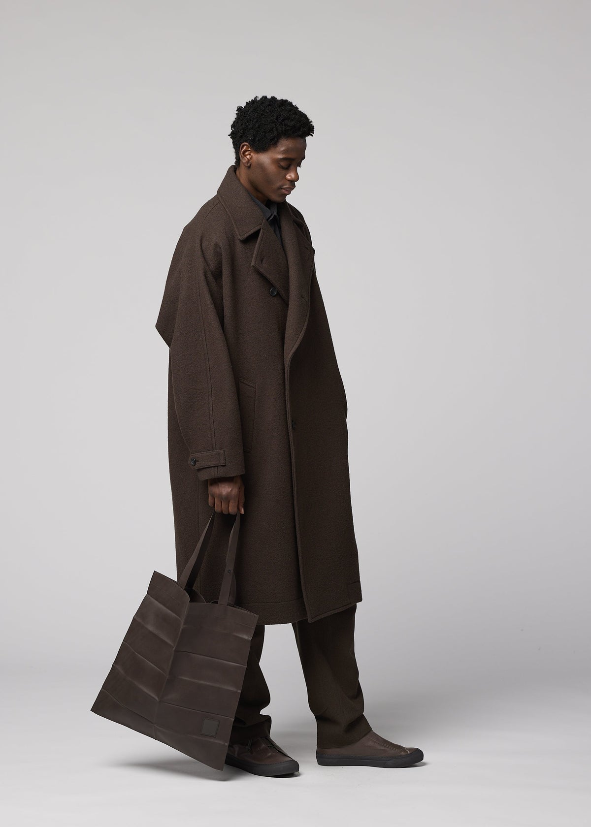 A model wears the IM MEN PATA PA pata-pa-tote-dark-brown.