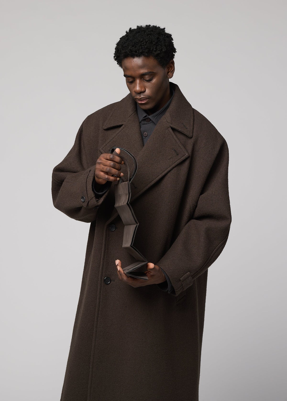 A model wears the IM MEN PATA PA pata-pa-tote-dark-brown.