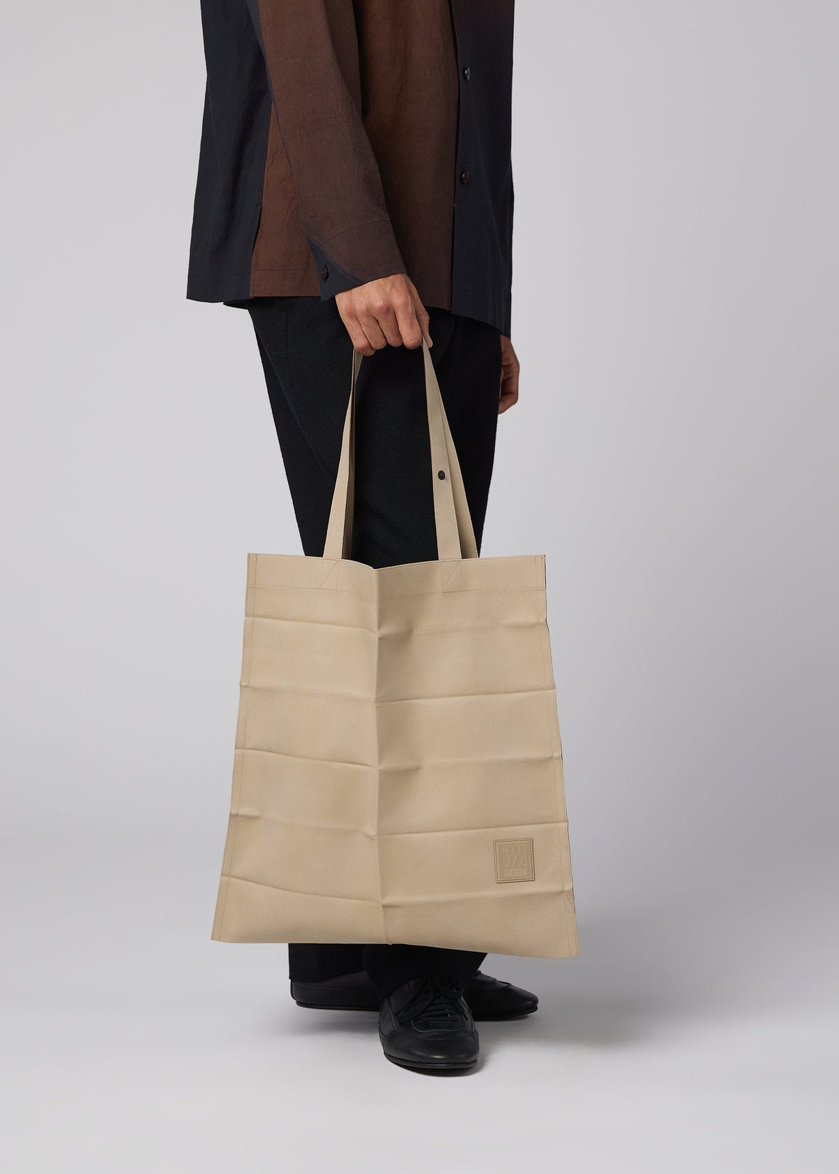 A model wears the IM MEN PATA PA pata-pa-tote-dark-brown.