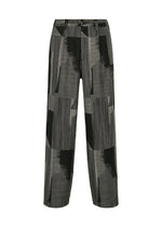 A product shot of the IM MEN KASURI trousers in black.