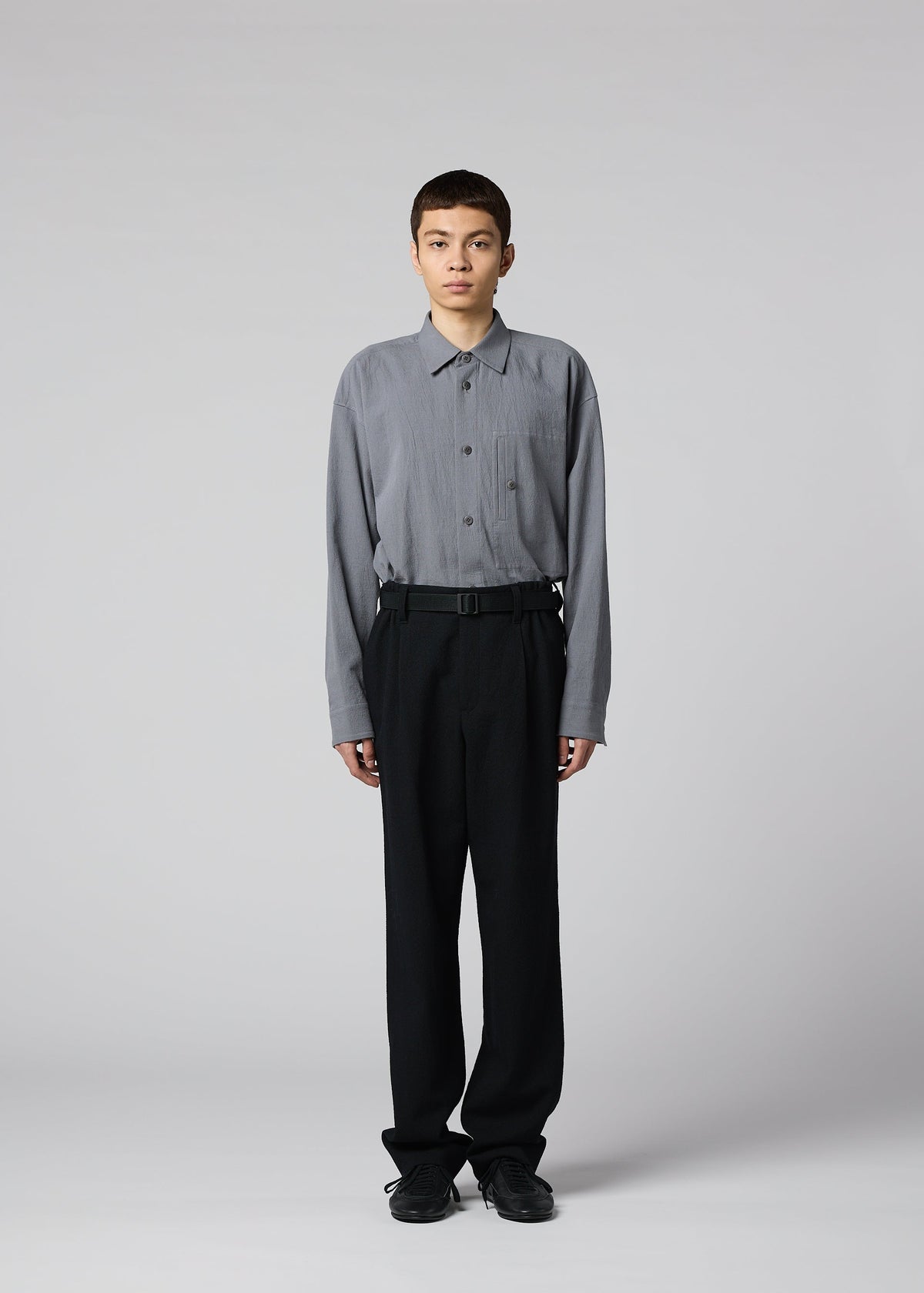 A model wears the IM MEN SHRINK WOOL shrink-wool-tapered-trousers-brown.