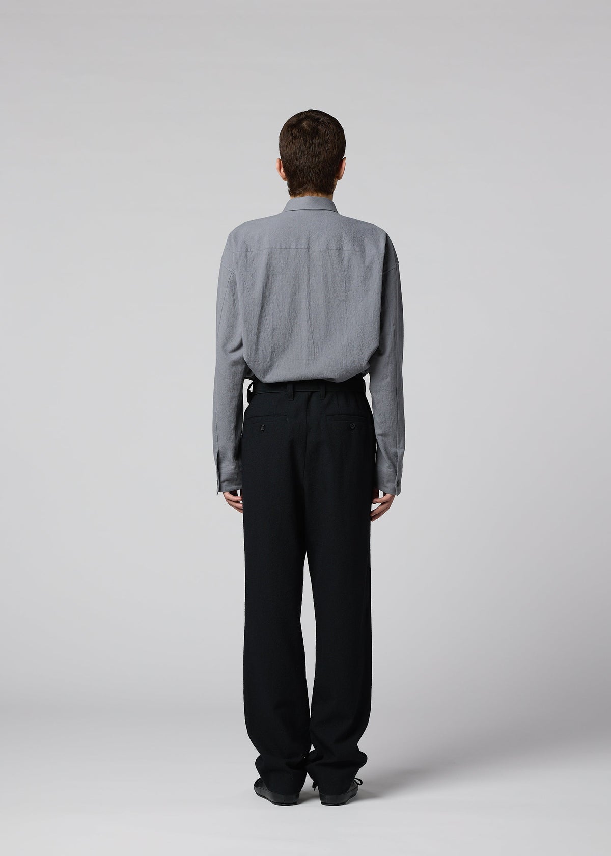 A model wears the IM MEN SHRINK WOOL shrink-wool-tapered-trousers-black.