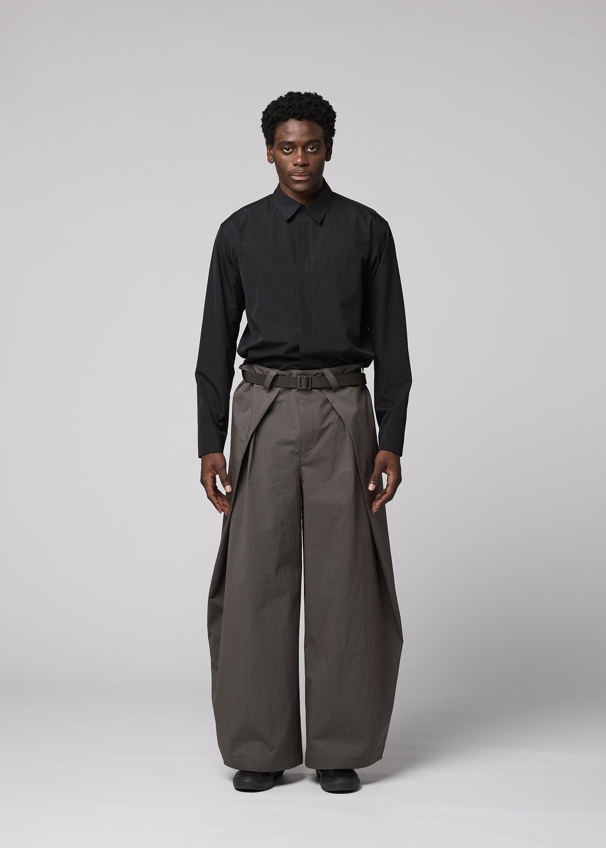 A model wears the IM MEN OVERLAP overlap-trousers-brown.