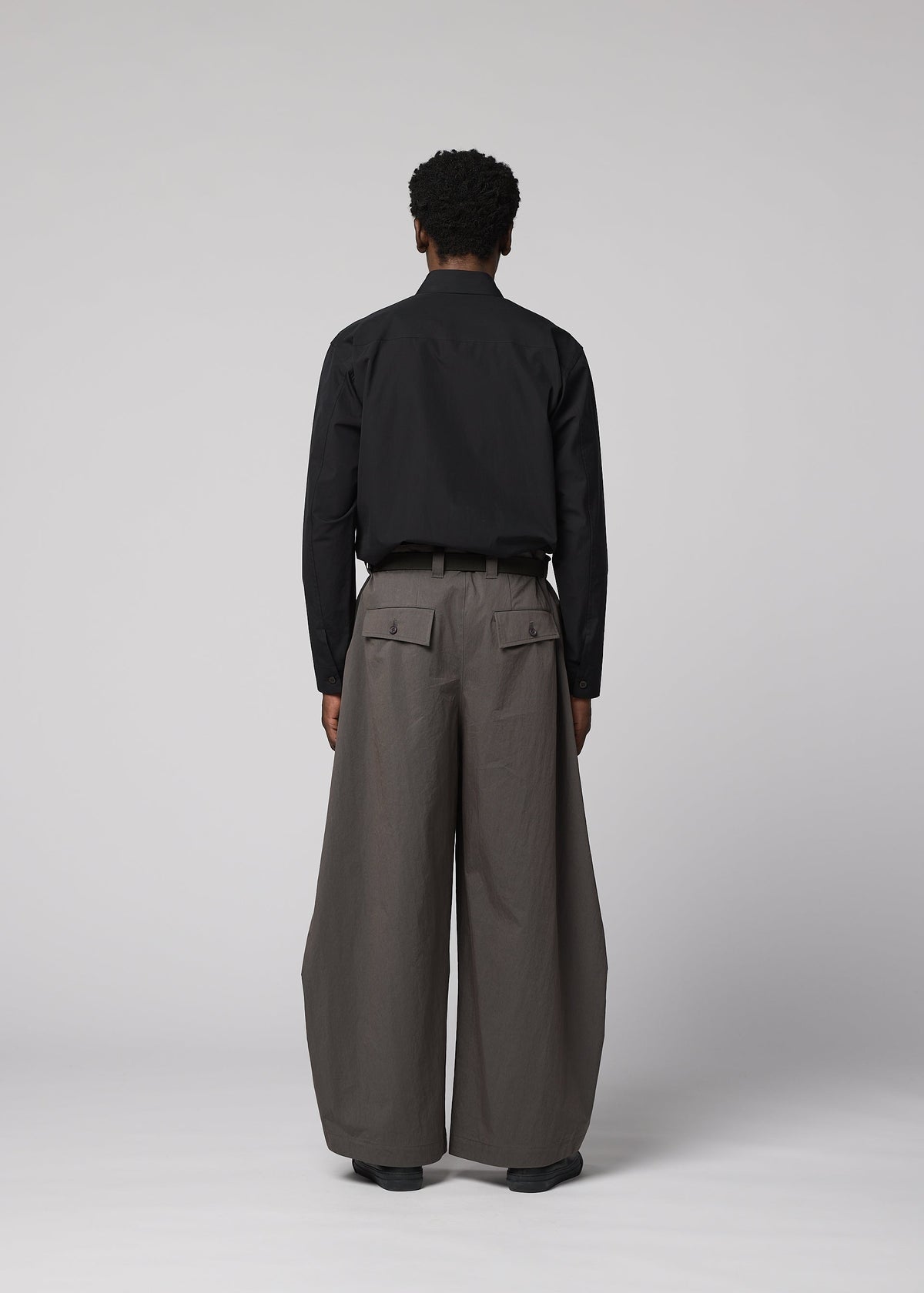A model wears the IM MEN OVERLAP overlap-trousers-brown.