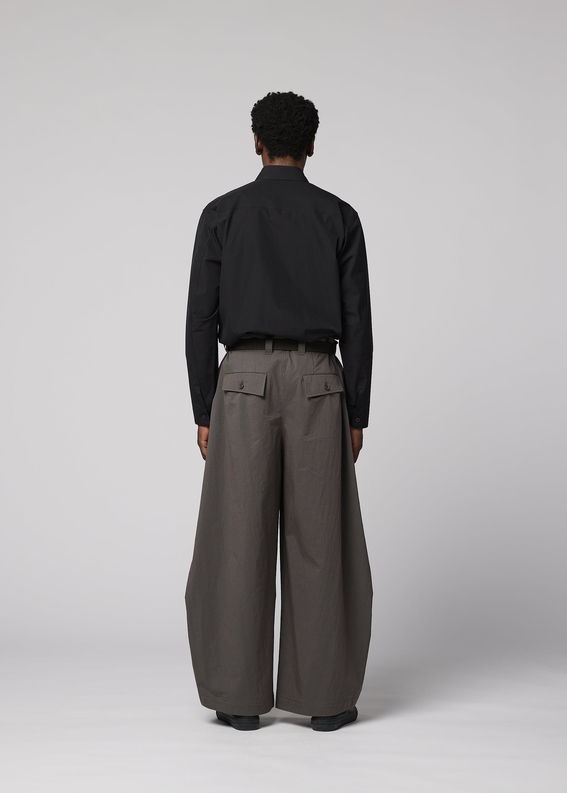 A model wears the IM MEN OVERLAP overlap-trousers-brown.