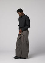A model wears the IM MEN OVERLAP overlap-trousers-brown.