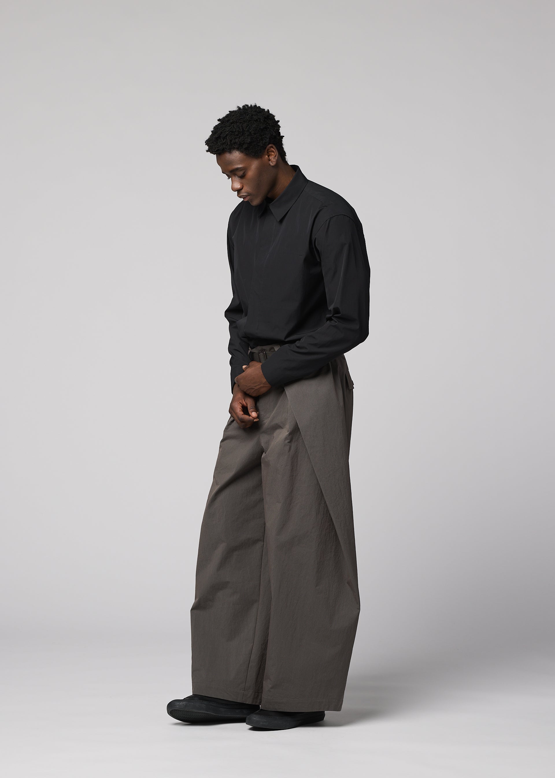 A model wears the IM MEN OVERLAP overlap-trousers-brown.