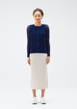 A model wears the PLEATS PLEASE ISSEY MIYAKE  TATAMI JULY cardigan