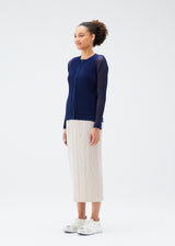 A model wears the PLEATS PLEASE ISSEY MIYAKE  TATAMI JULY cardigan