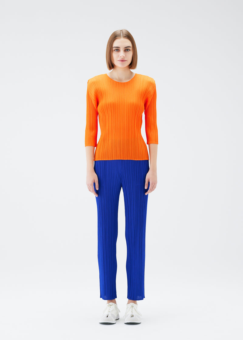 A model wears the PLEATS PLEASE ISSEY MIYAKE  MONTHLY COLORS JULY trousers