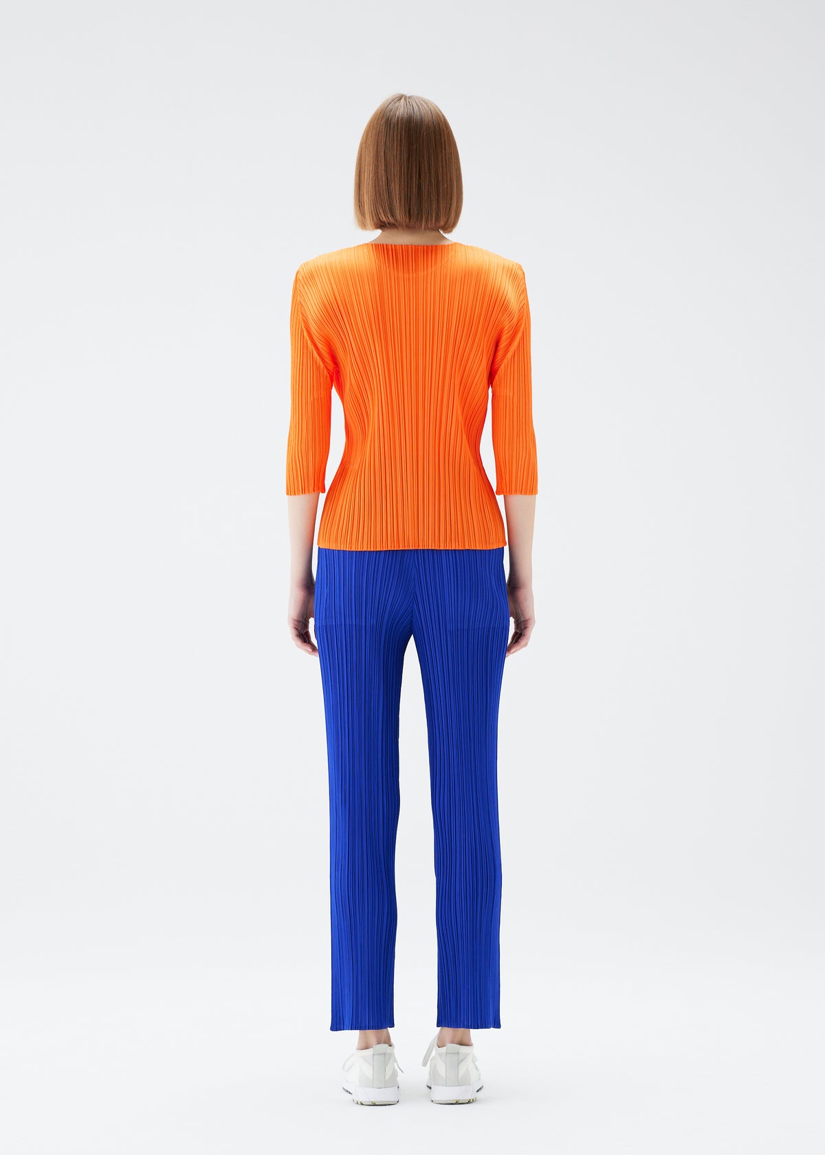 A model wears the PLEATS PLEASE ISSEY MIYAKE  MONTHLY COLORS JULY trousers