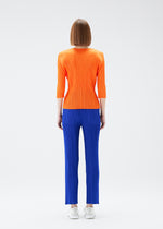 A model wears the PLEATS PLEASE ISSEY MIYAKE  MONTHLY COLORS JULY trousers