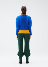 A model wears the PLEATS PLEASE ISSEY MIYAKE MONTHLY COLORS OCTOBER trousers.