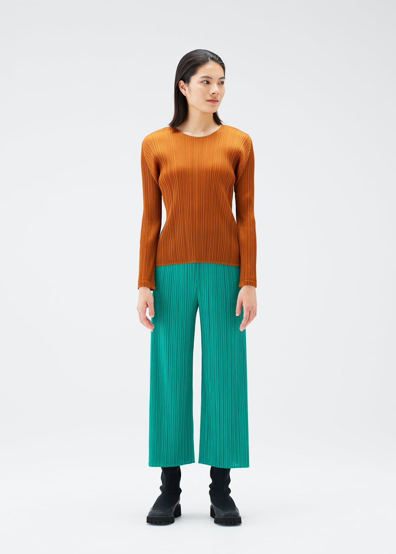 A model wears the PLEATS PLEASE ISSEY MIYAKE MONTHLY COLORS NOVEMBER trousers.