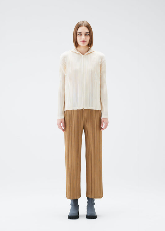 A model wears the PLEATS PLEASE ISSEY MIYAKE MONTHLY COLORS DECEMBER trousers.