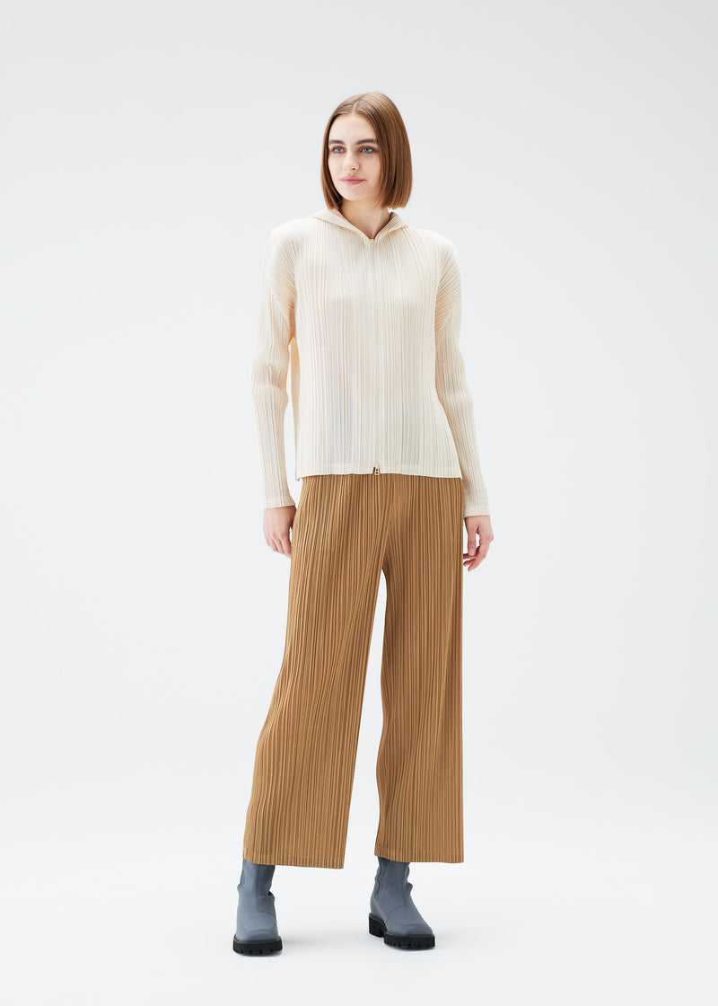 A model wears the PLEATS PLEASE ISSEY MIYAKE MONTHLY COLORS DECEMBER trousers.