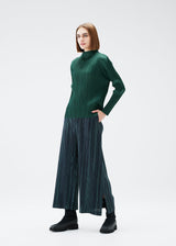 A model wears the PLEATS PLEASE ISSEY MIYAKE METEOR SHOWER trousers.