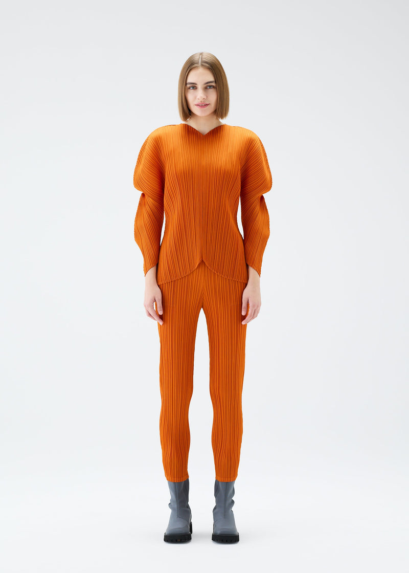 A model wears the PLEATS PLEASE ISSEY MIYAKE WORMHOLE trousers.