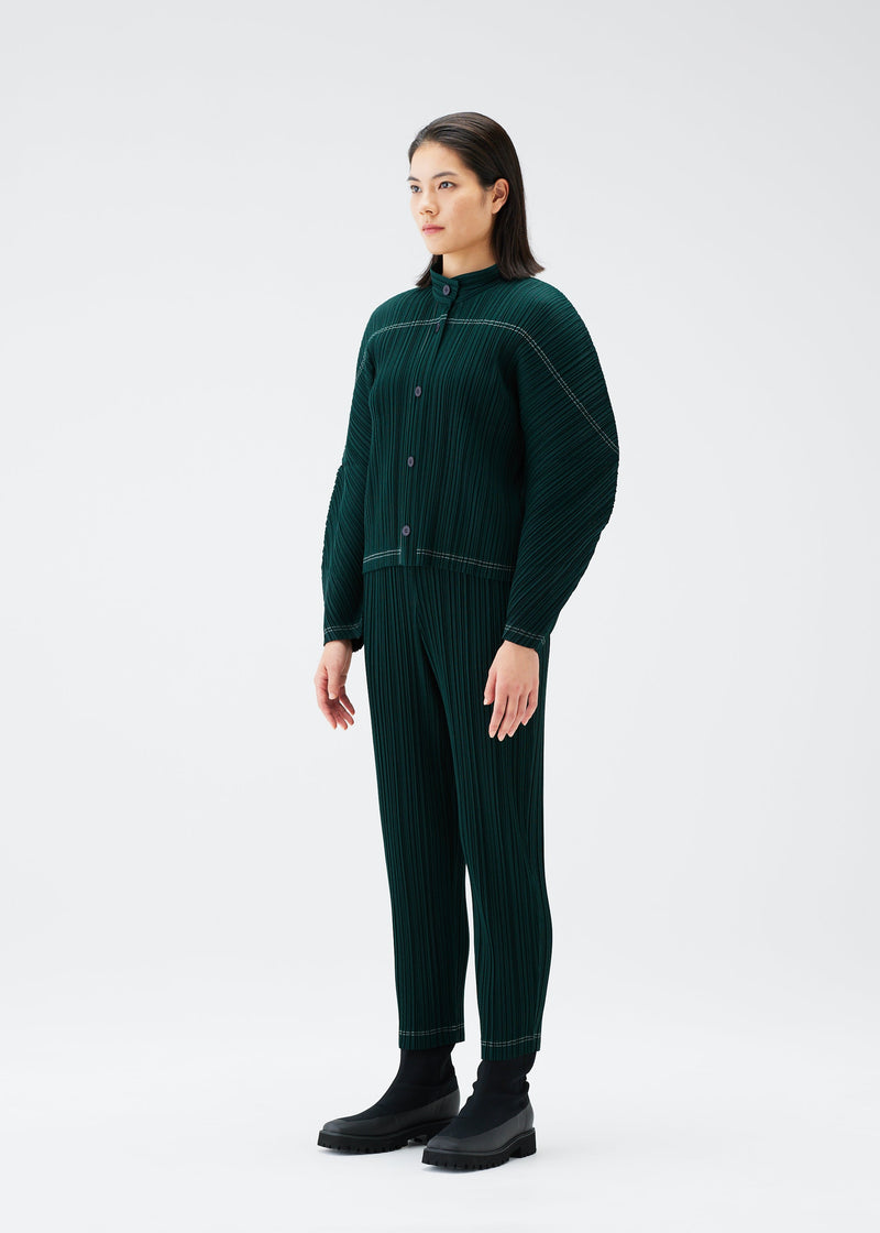 A model wears the PLEATS PLEASE ISSEY MIYAKE RAMIE PLEATS trousers.