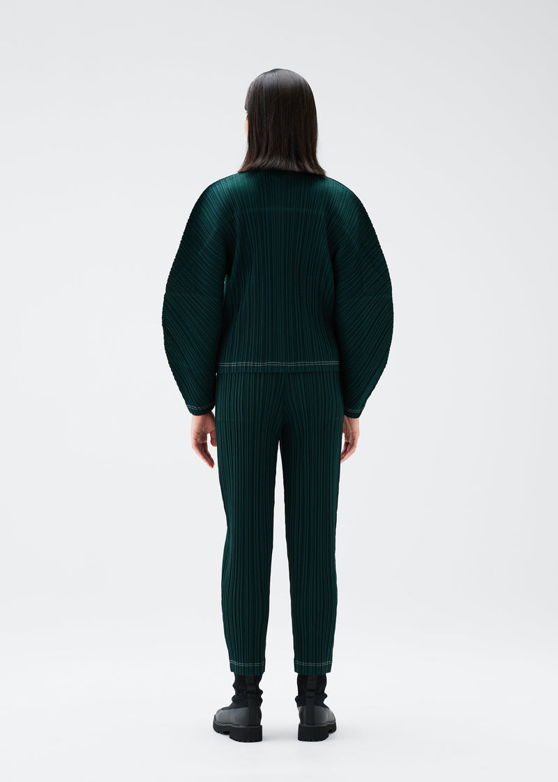 A model wears the PLEATS PLEASE ISSEY MIYAKE RAMIE PLEATS trousers.