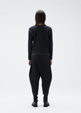 A model wears the PLEATS PLEASE ISSEY MIYAKE RAMIE PLEATS trousers.