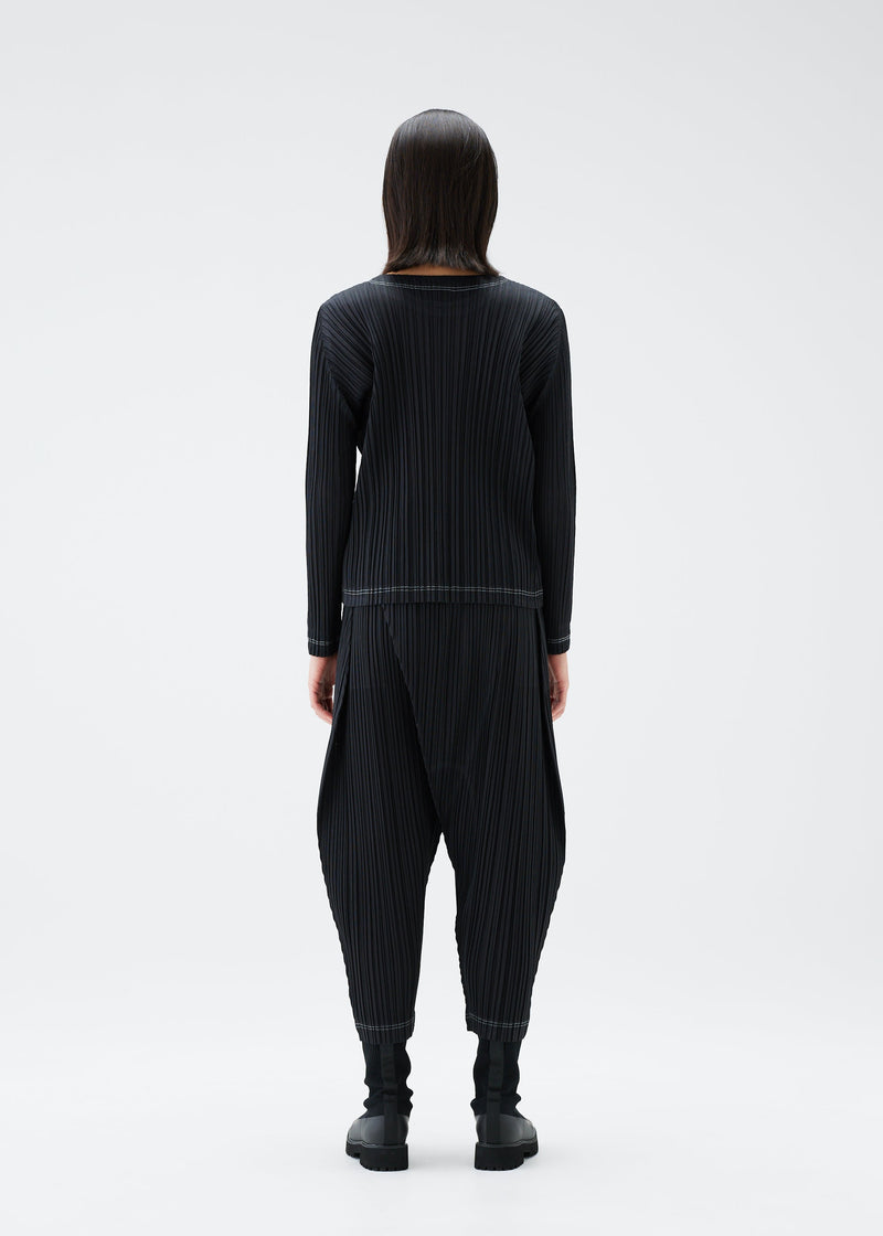 A model wears the PLEATS PLEASE ISSEY MIYAKE RAMIE PLEATS trousers.