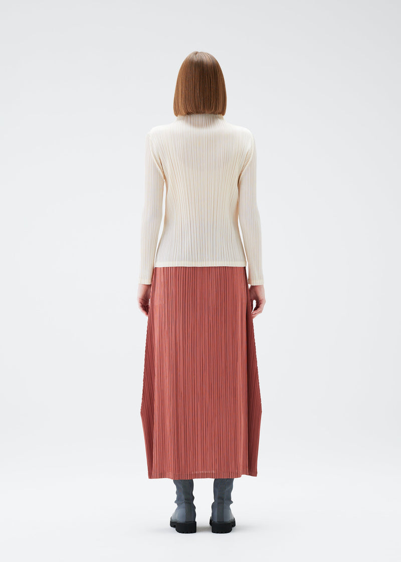 A model wears the PLEATS PLEASE ISSEY MIYAKE MONTHLY COLORS DECEMBER top.