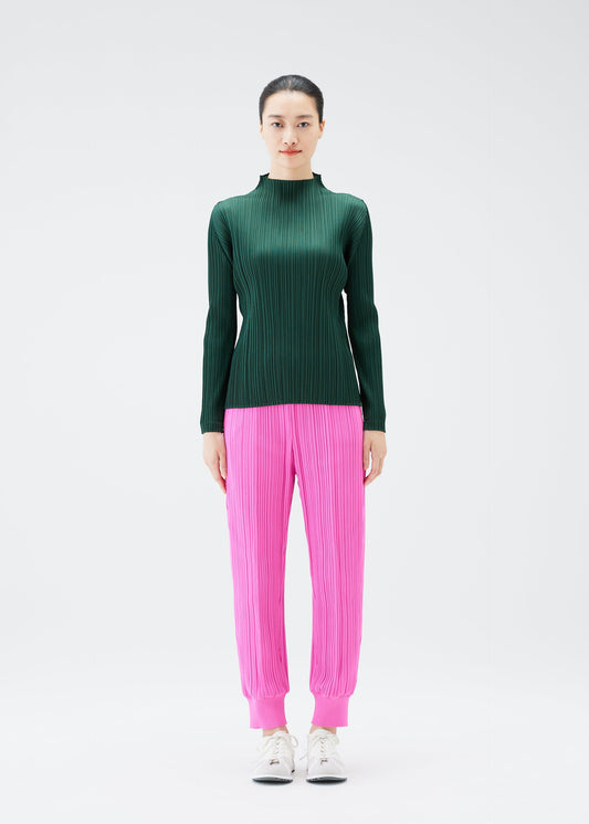 A model wears the PLEATS PLEASE ISSEY MIYAKE CREPE KNIT trousers.