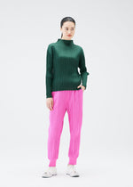 A model wears the PLEATS PLEASE ISSEY MIYAKE CREPE KNIT trousers.