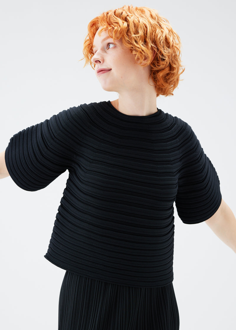 A model wears the PLEATS PLEASE ISSEY MIYAKE  MUSHROOM KNIT top