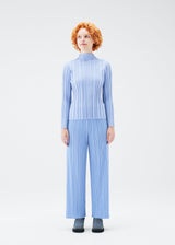 A model wears the PLEATS PLEASE ISSEY MIYAKE PLANET KNIT top.