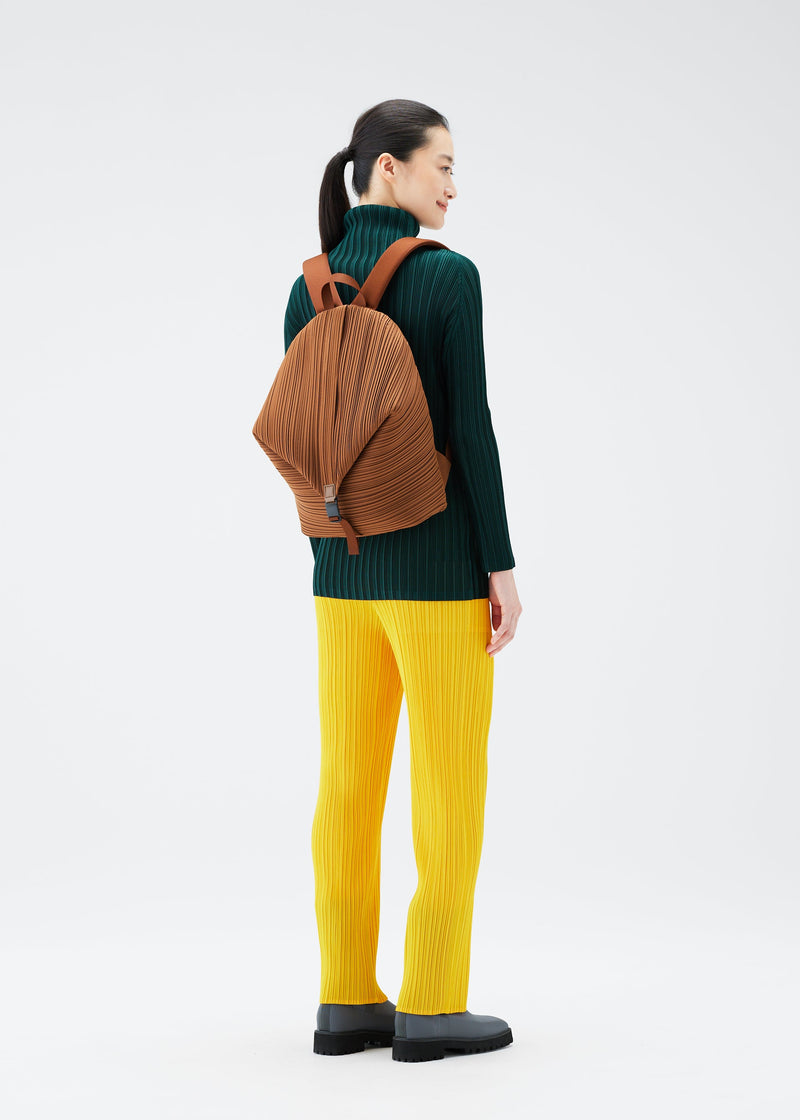 A model wears the PLEATS PLEASE ISSEY MIYAKE PLEATS BACKPACK bag.