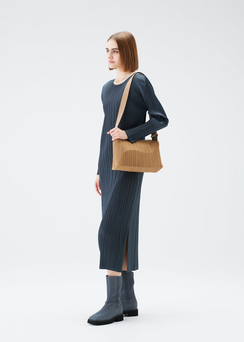 A model wears the PLEATS PLEASE ISSEY MIYAKE PLANETARY PLEATS BAG bag.