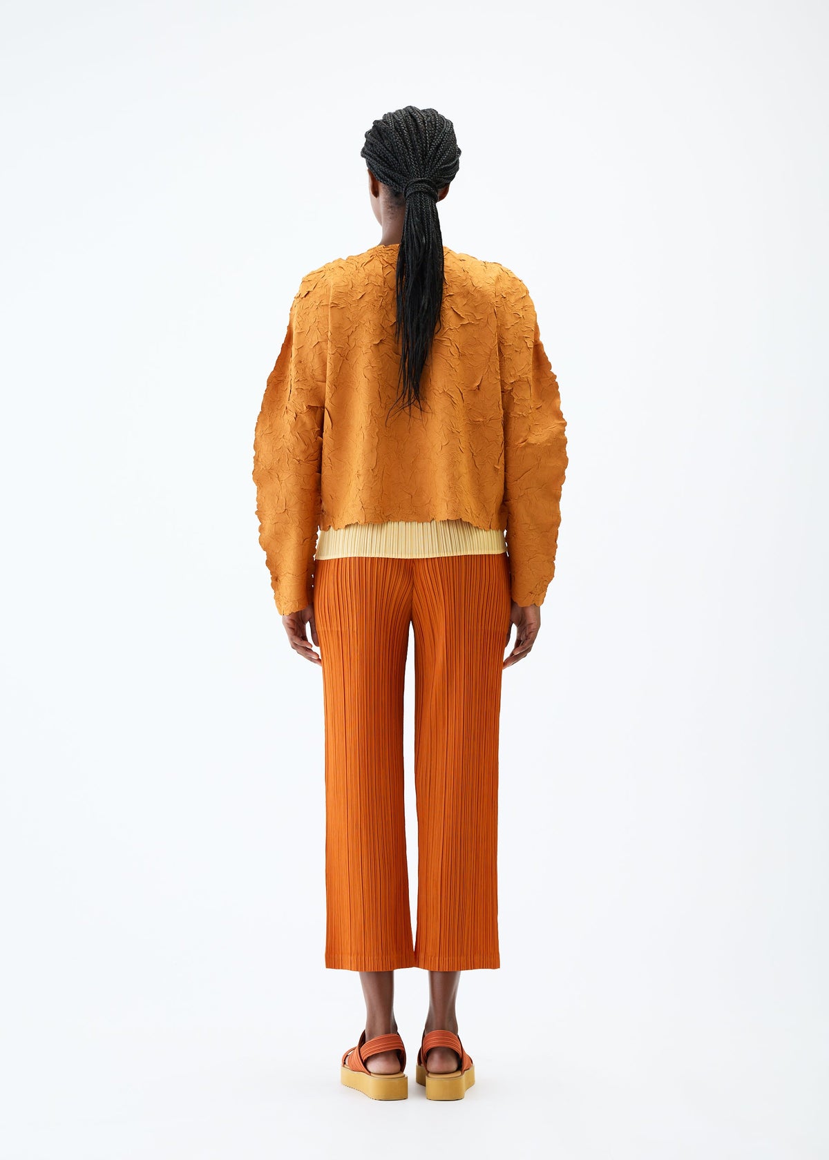 A model wears the PLEATS PLEASE ISSEY MIYAKE CRUSH PRESS jacket.