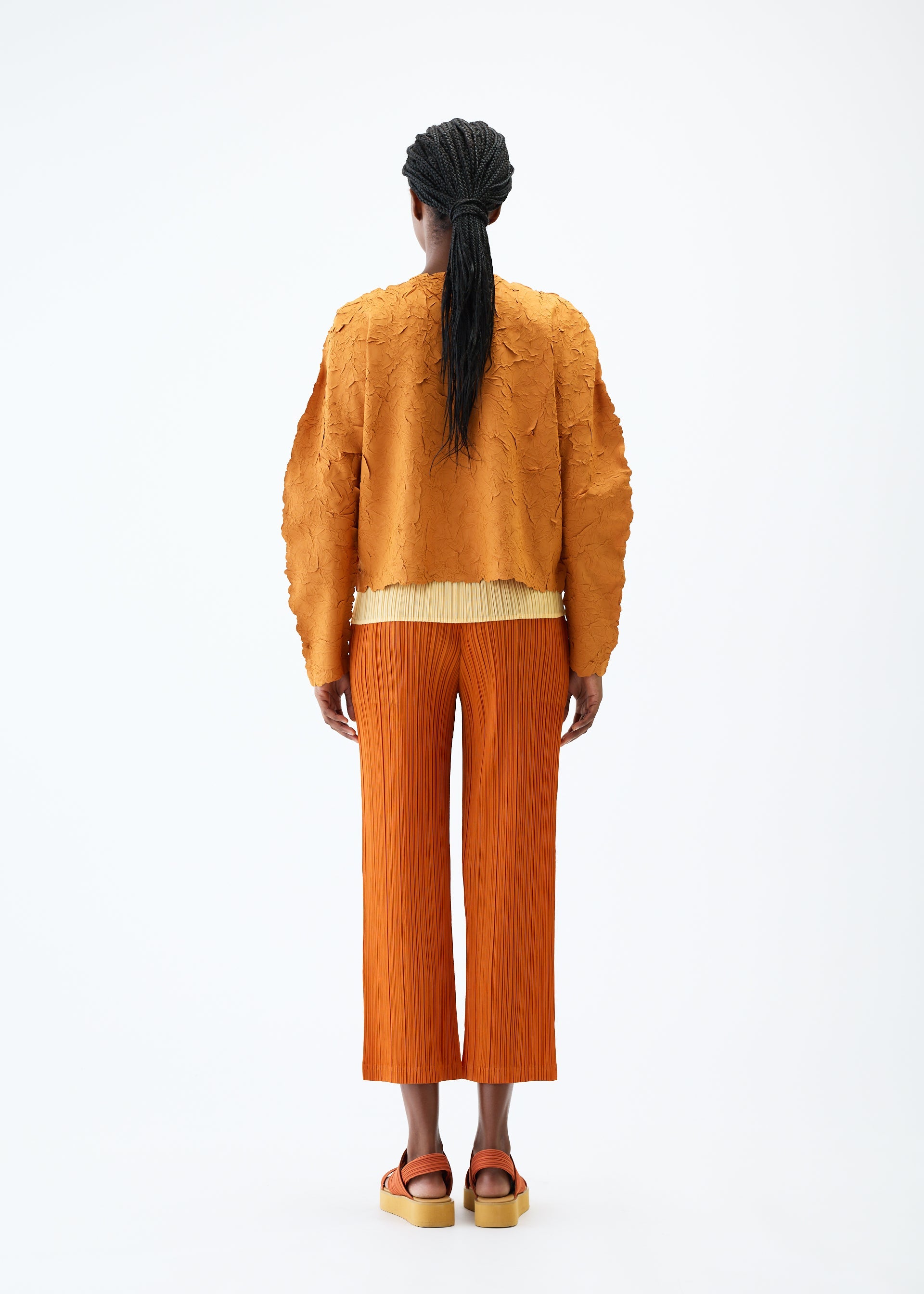 A model wears the PLEATS PLEASE ISSEY MIYAKE CRUSH PRESS jacket.