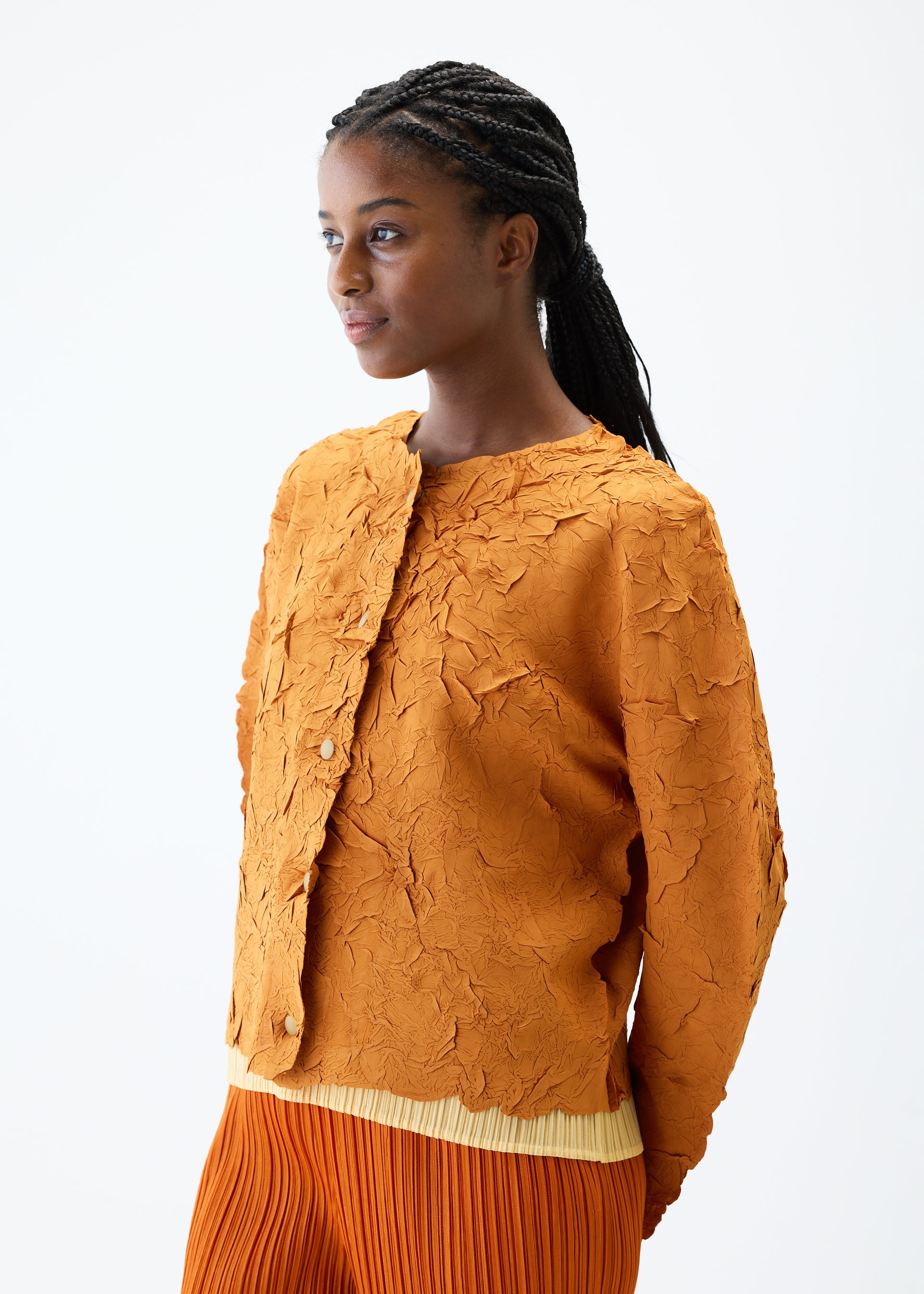 A model wears the PLEATS PLEASE ISSEY MIYAKE CRUSH PRESS jacket.
