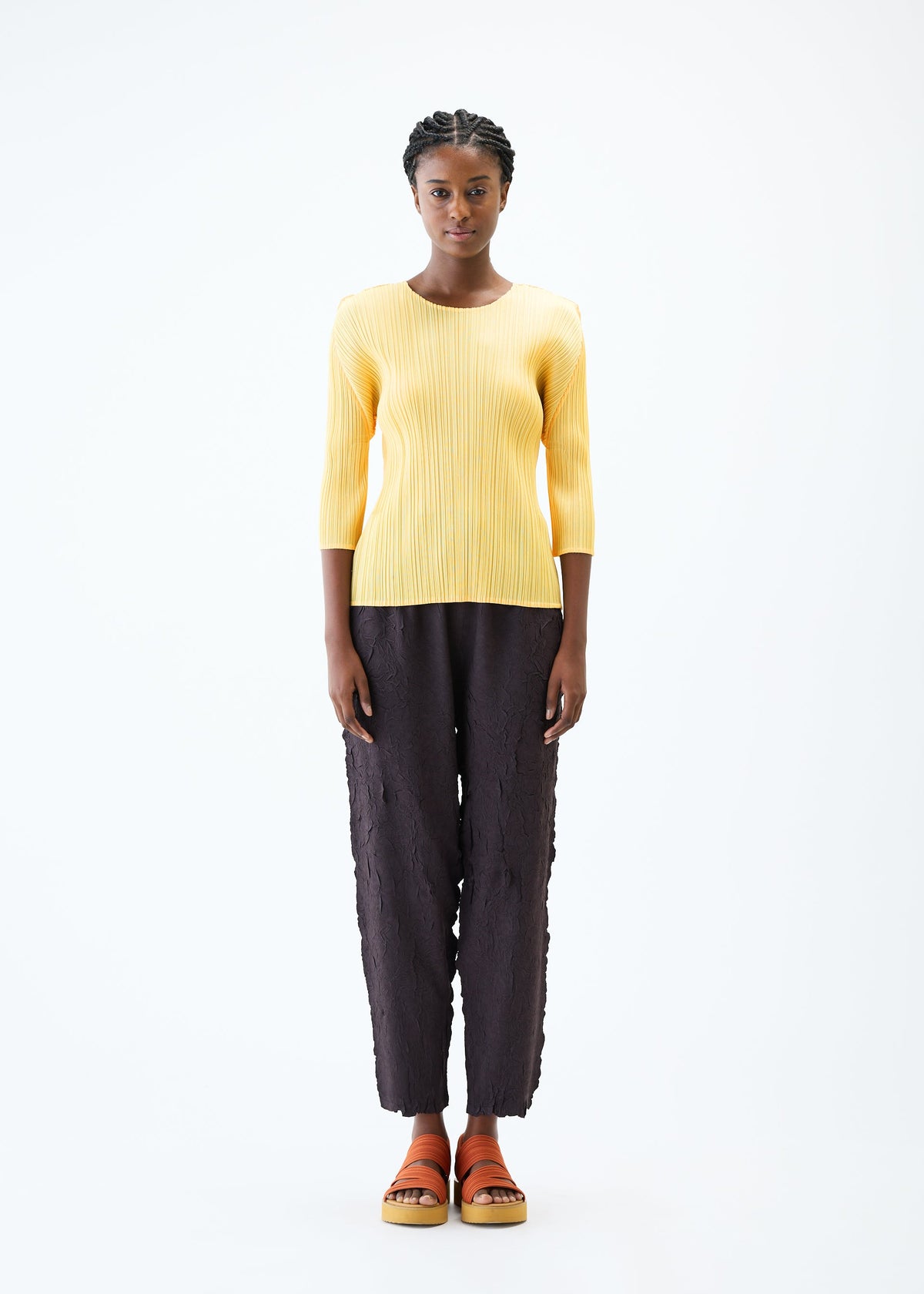 A model wears the PLEATS PLEASE ISSEY MIYAKE CRUSH PRESS trousers.