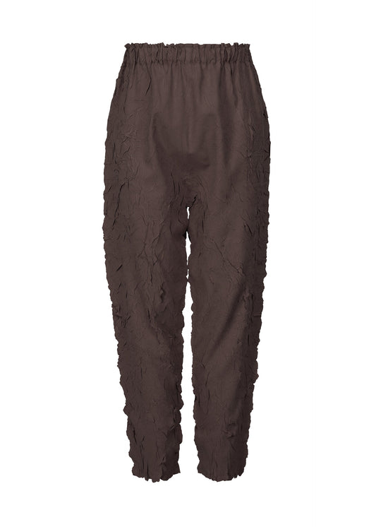 A product shot of the PLEATS PLEASE ISSEY MIYAKE CRUSH PRESS trousers in dark brown (45).