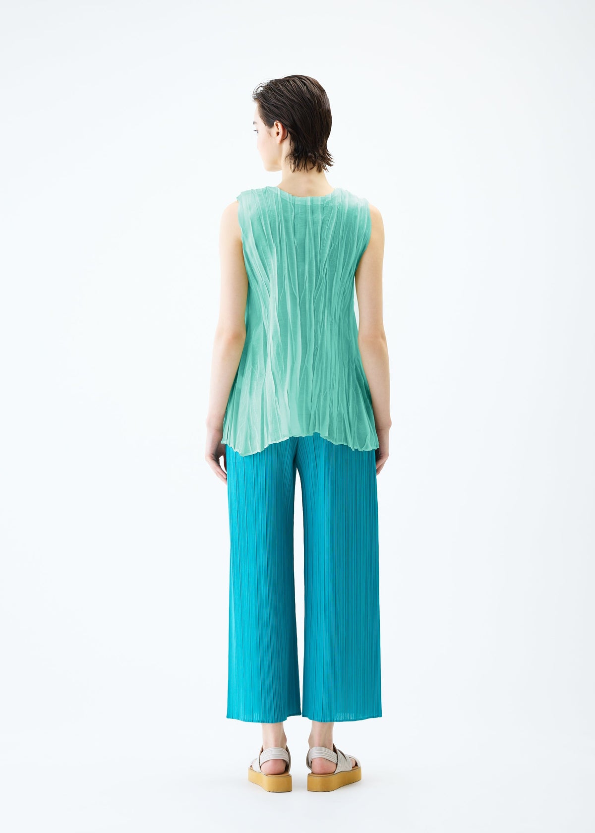 A model wears the PLEATS PLEASE ISSEY MIYAKE SHEER TWIST top.