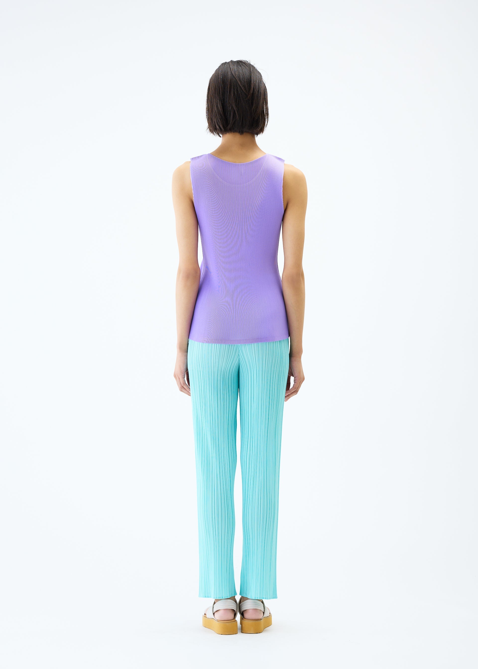 A model wears the PLEATS PLEASE ISSEY MIYAKE MIST APRIL top.