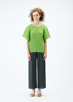 A model wears the PLEATS PLEASE ISSEY MIYAKE MIST JUNE top.