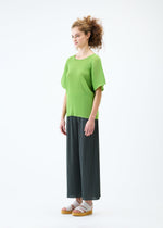 A model wears the PLEATS PLEASE ISSEY MIYAKE MIST JUNE top.