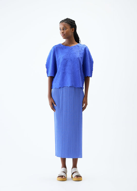 A model wears the PLEATS PLEASE ISSEY MIYAKE CRUSH PRESS top.