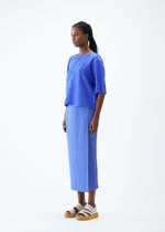 A model wears the PLEATS PLEASE ISSEY MIYAKE CRUSH PRESS top.