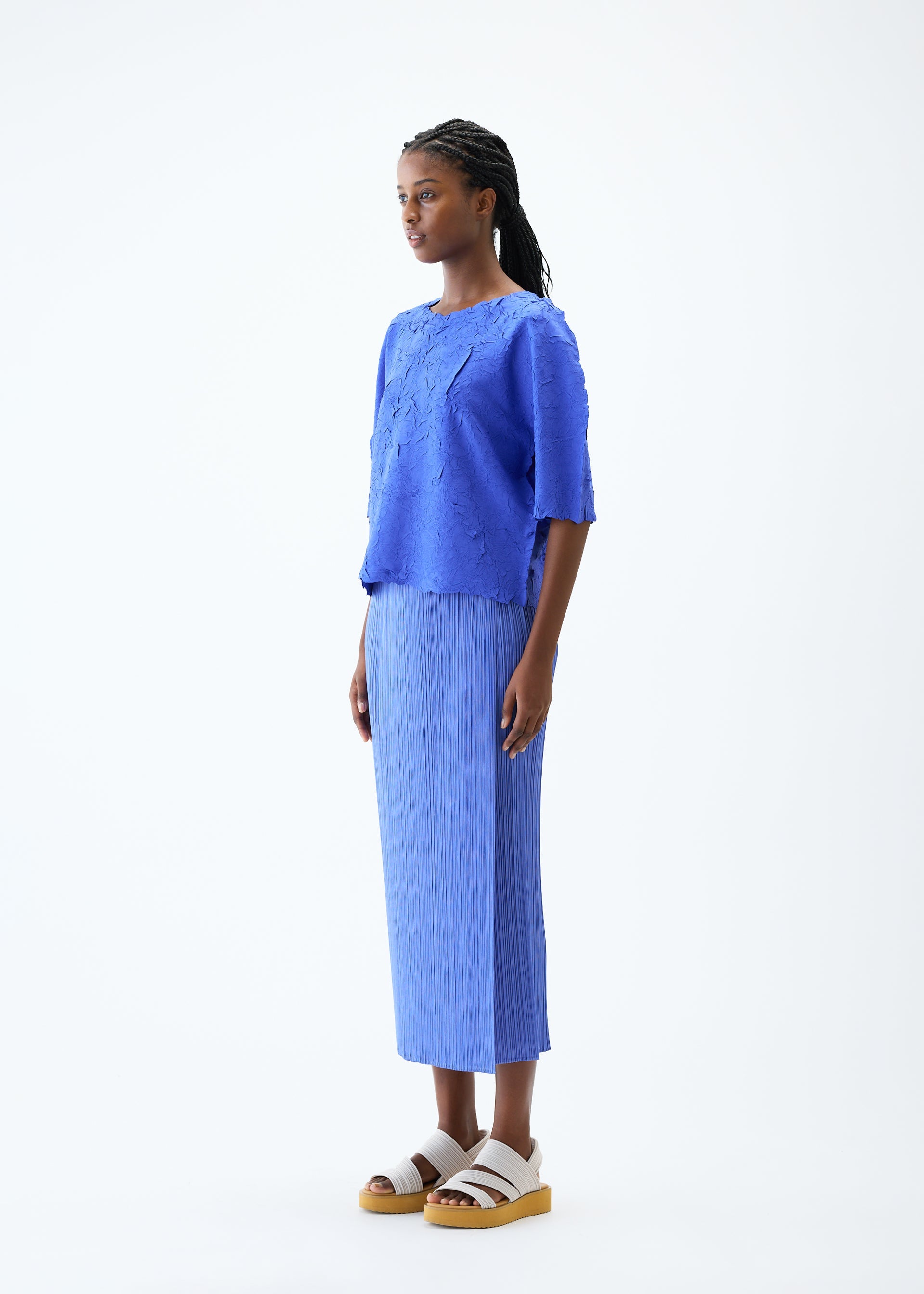 A model wears the PLEATS PLEASE ISSEY MIYAKE CRUSH PRESS top.