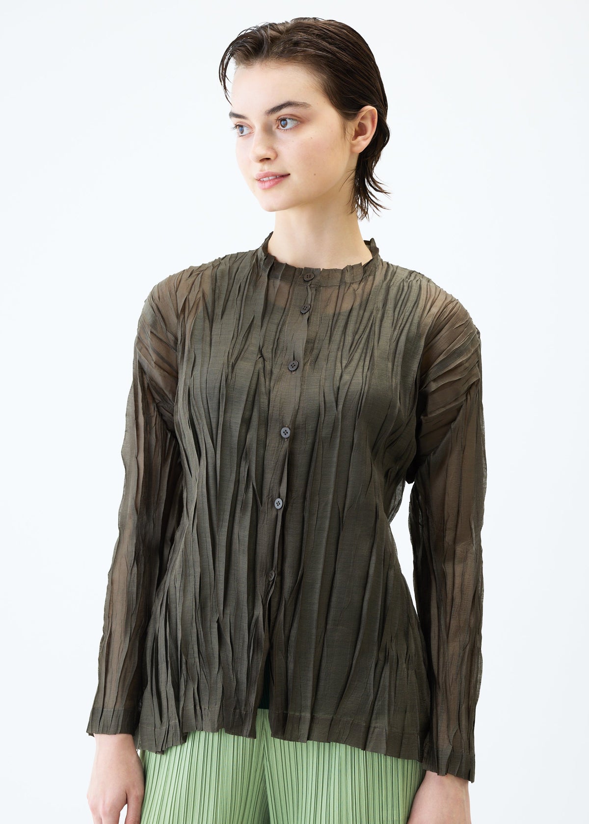 A model wears the PLEATS PLEASE ISSEY MIYAKE SHEER TWIST cardigan.