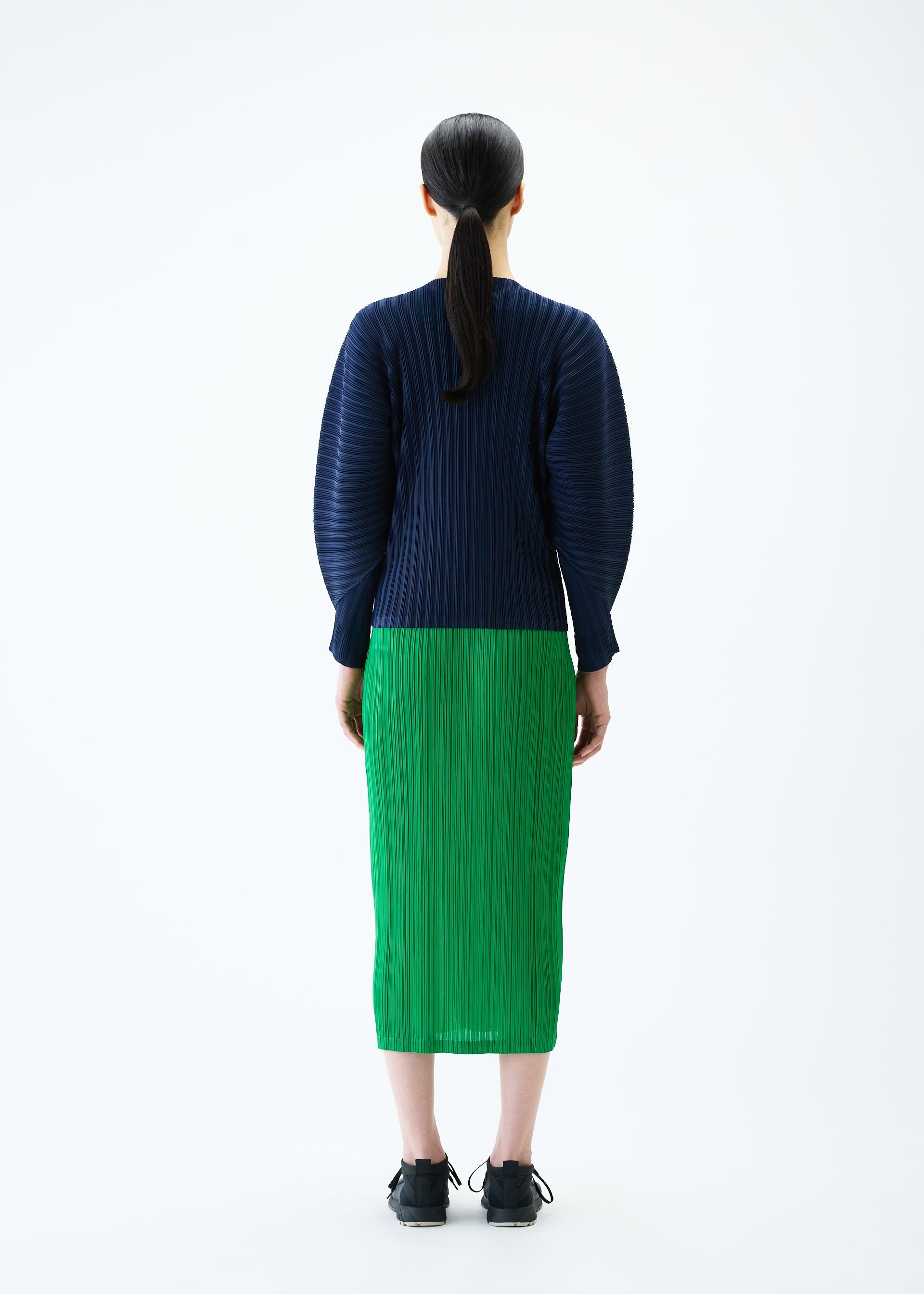 A model wears the PLEATS PLEASE ISSEY MIYAKE RIB PLEATS FEBRUARY cardigan.