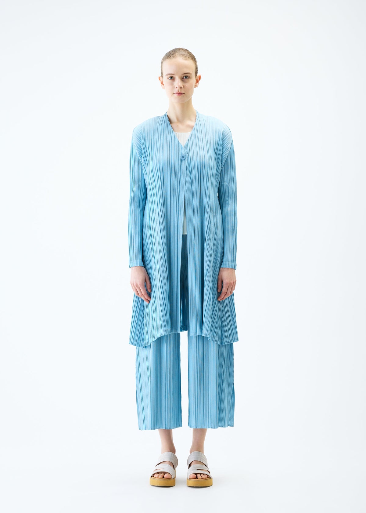 A model wears the PLEATS PLEASE ISSEY MIYAKE MELLOW PLEATS coat.